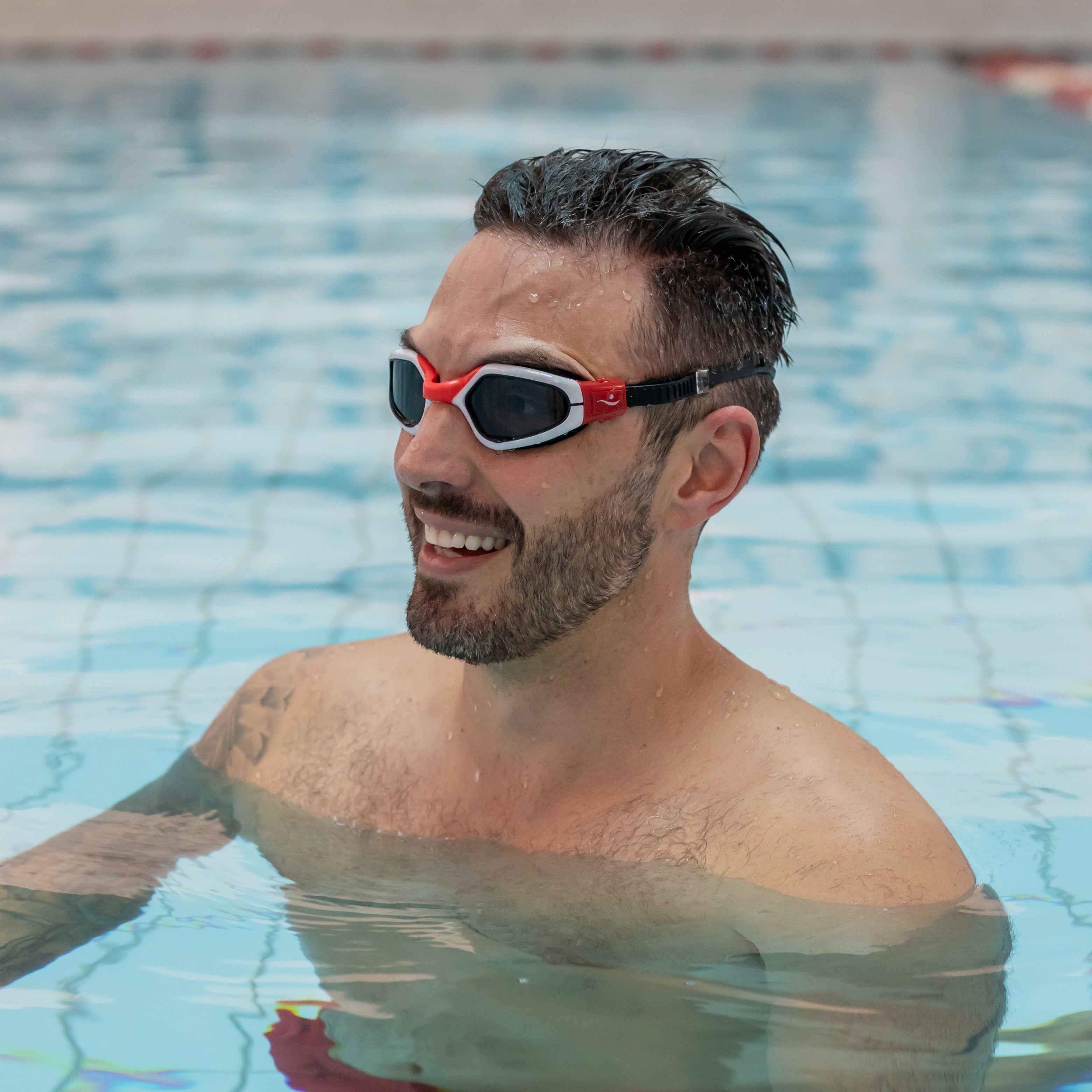 Man wearing red swim goggles in a pool